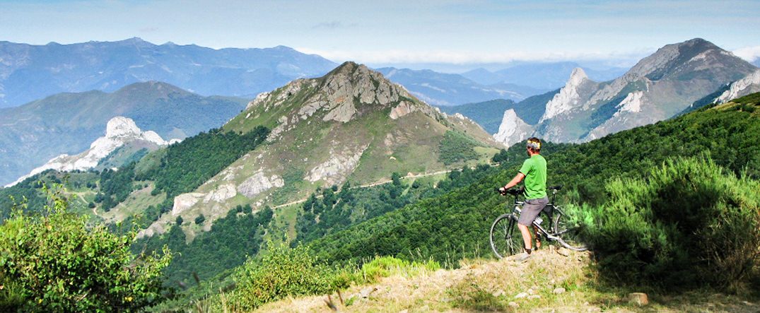 Cyclist watching mountains in Cantabria