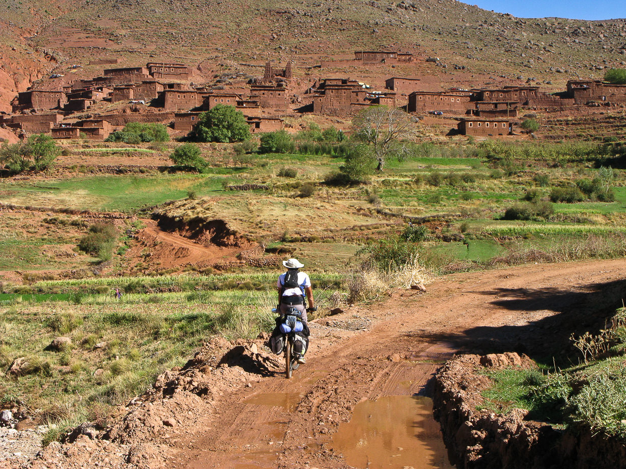 Biker passing through adobe villages in Atlas